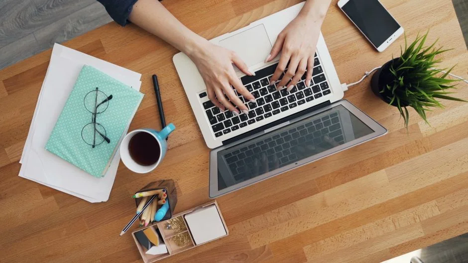 services-02 Une scène chaleureuse de bureau à domicile avec un ordinateur portable, un carnet, un smartphone et un café, idéale pour rester productif.